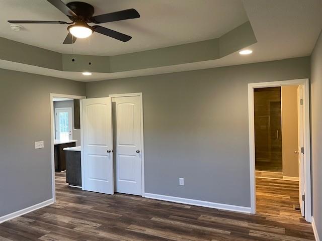unfurnished bedroom with dark wood finished floors, recessed lighting, a closet, ceiling fan, and baseboards