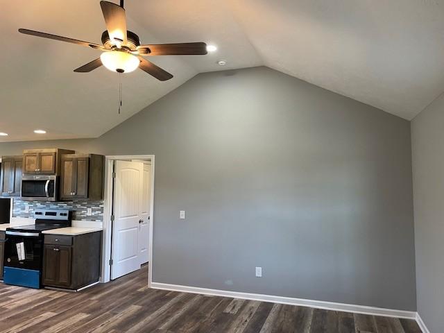 kitchen featuring range with electric cooktop, stainless steel microwave, ceiling fan, dark wood-style flooring, and vaulted ceiling