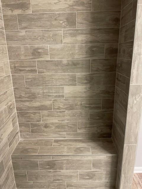 interior details featuring tiled shower