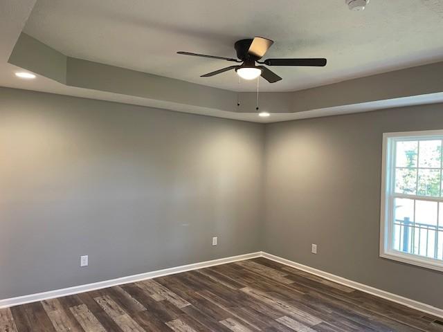 spare room with baseboards, recessed lighting, ceiling fan, and dark wood-style floors
