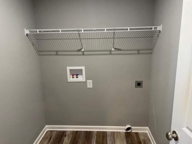 laundry area with electric dryer hookup, baseboards, and dark wood-style floors