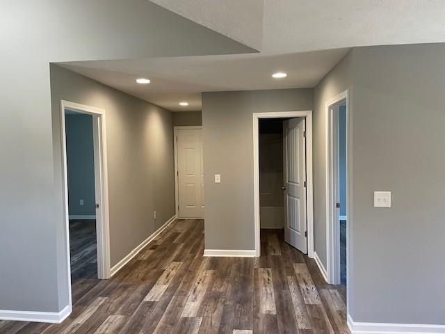 interior space featuring recessed lighting, dark wood finished floors, and baseboards