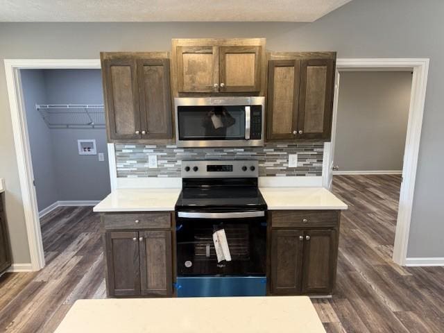 kitchen featuring baseboards, tasteful backsplash, stainless steel appliances, and light countertops