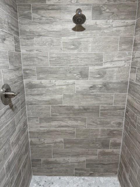 full bathroom featuring tiled shower
