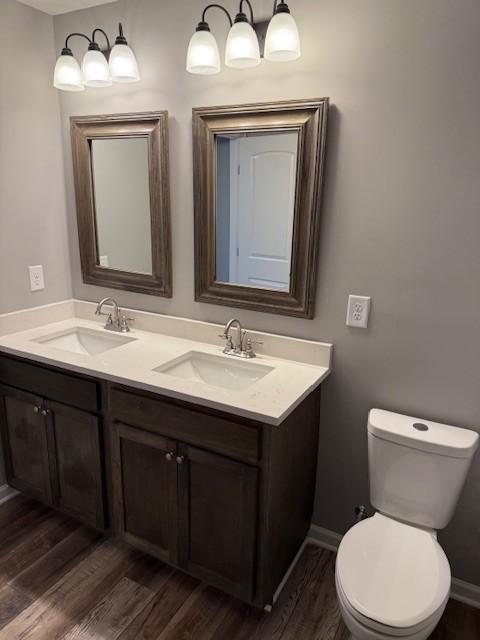 bathroom with wood finished floors, toilet, and a sink