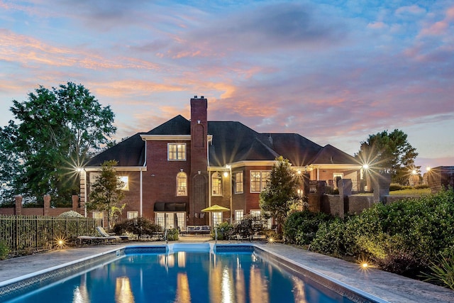 view of pool at dusk