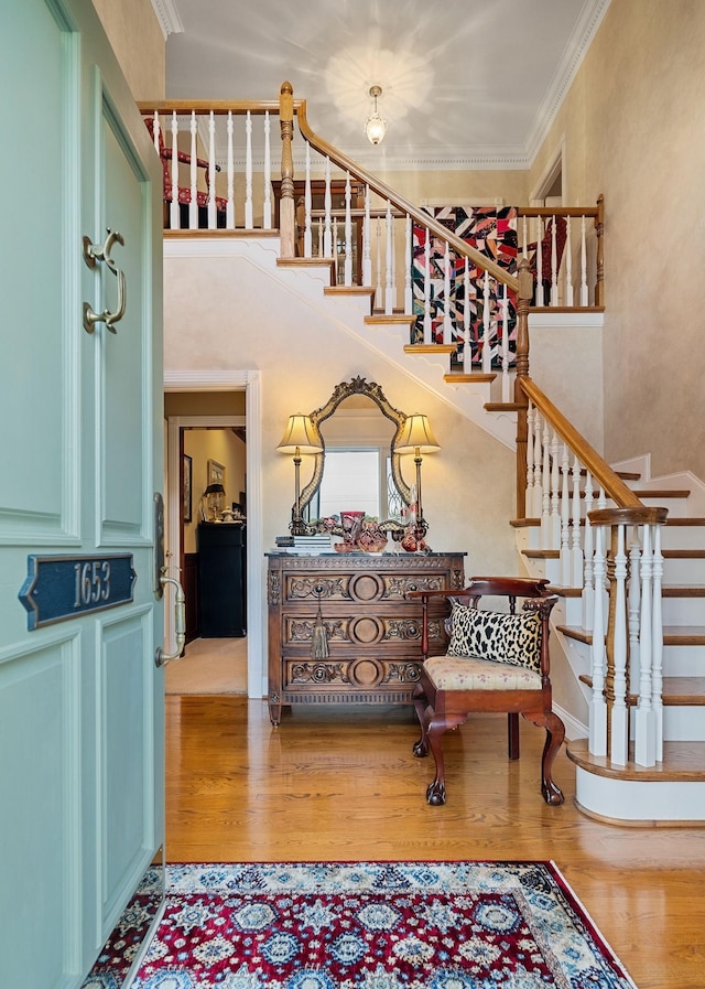 stairway featuring crown molding and hardwood / wood-style floors