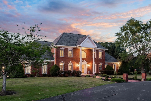 colonial-style house featuring a lawn