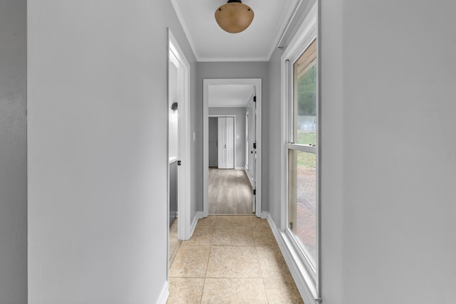 corridor with ornamental molding and light tile patterned flooring