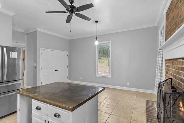 kitchen with white cabinets, stainless steel refrigerator, ceiling fan, pendant lighting, and ornamental molding