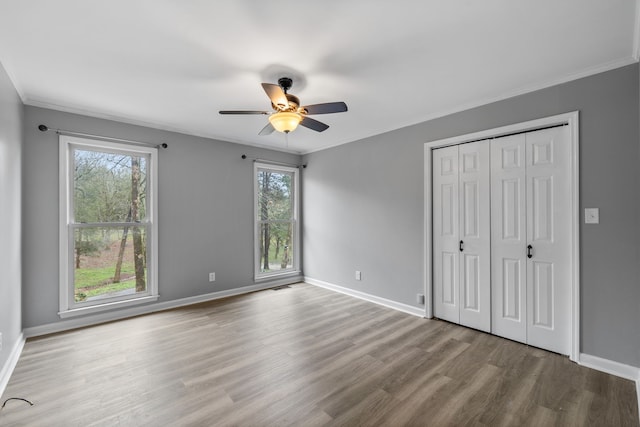 unfurnished bedroom with light hardwood / wood-style flooring, ceiling fan, and ornamental molding