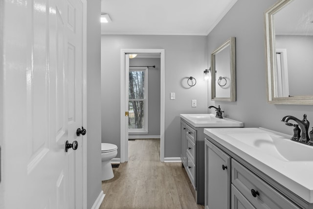 bathroom featuring vanity, toilet, ornamental molding, and hardwood / wood-style floors