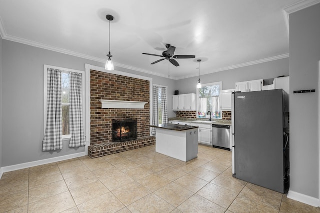 kitchen featuring a fireplace, appliances with stainless steel finishes, sink, ceiling fan, and white cabinets