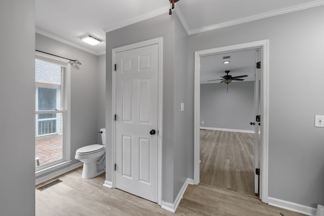 bathroom with crown molding, toilet, hardwood / wood-style flooring, and ceiling fan