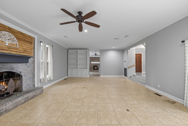 unfurnished living room featuring built in shelves, ceiling fan, ornamental molding, and a brick fireplace