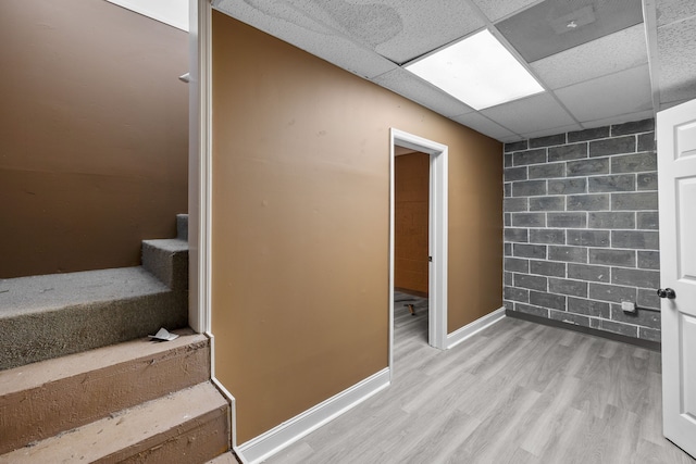 interior space featuring wood-type flooring and a drop ceiling