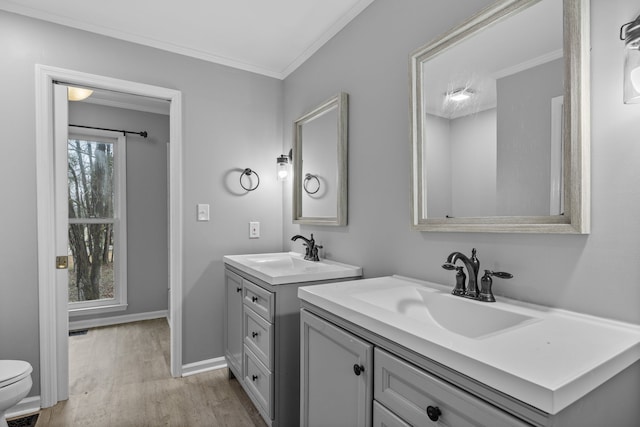 bathroom featuring wood-type flooring, toilet, crown molding, and vanity