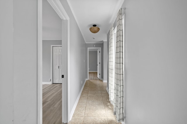 hallway featuring ornamental molding and light hardwood / wood-style flooring