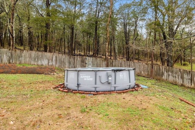 view of outdoor structure with a yard and a fenced in pool