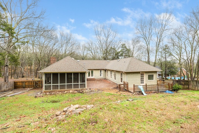 back of property featuring a sunroom and a yard