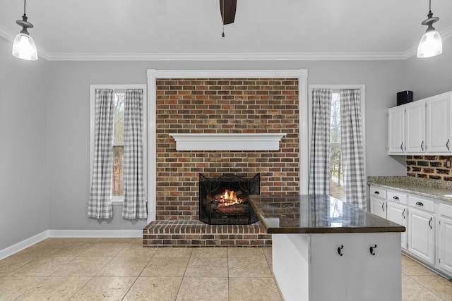 kitchen with a wealth of natural light, pendant lighting, a brick fireplace, and white cabinets