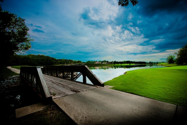 dock area with a water view and a yard