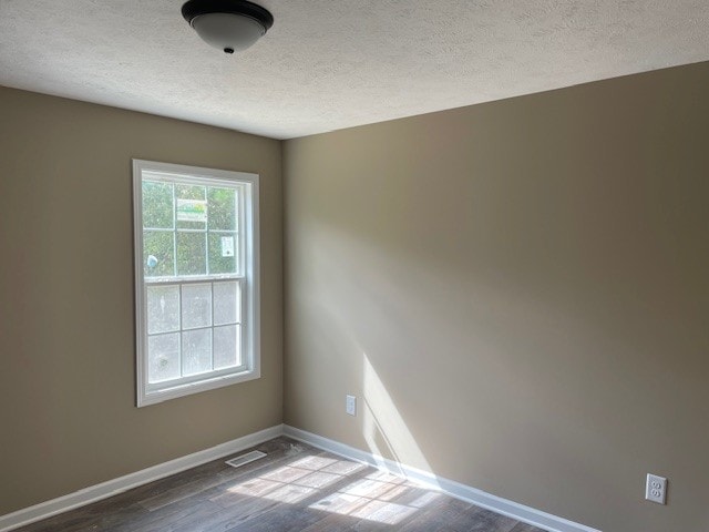 empty room featuring a textured ceiling and hardwood / wood-style flooring