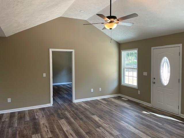 foyer entrance with dark wood-style floors, a textured ceiling, ceiling fan, and lofted ceiling