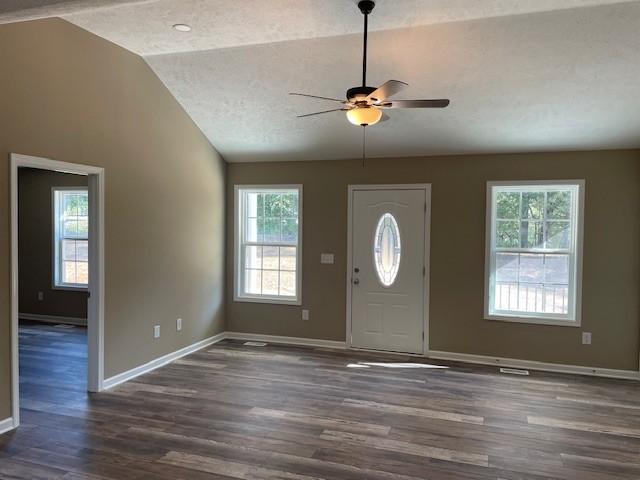 foyer with dark wood-style flooring, a ceiling fan, baseboards, a textured ceiling, and lofted ceiling