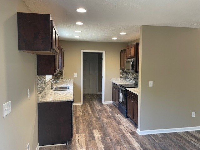 kitchen with dark hardwood / wood-style flooring, black range with electric cooktop, dark brown cabinetry, sink, and backsplash