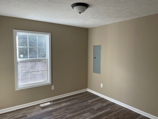 unfurnished room featuring electric panel, a textured ceiling, and dark hardwood / wood-style flooring