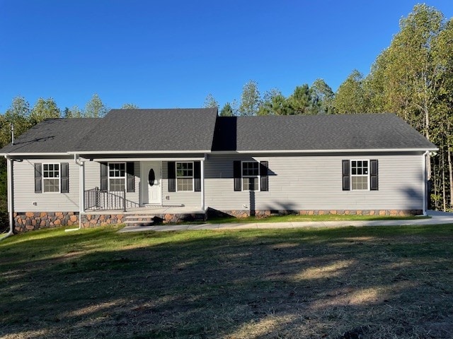 ranch-style house featuring covered porch and a front lawn