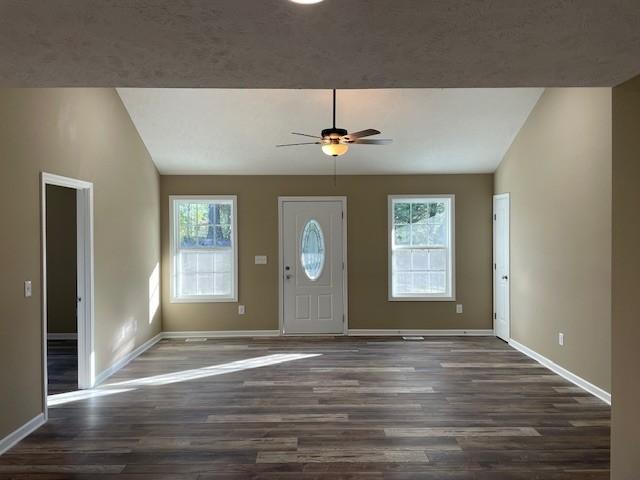 foyer entrance with lofted ceiling, wood finished floors, ceiling fan, and baseboards