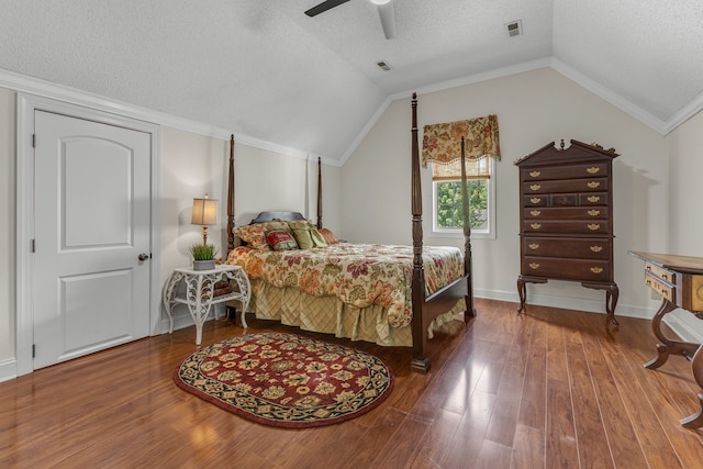 bedroom featuring lofted ceiling, crown molding, a textured ceiling, ceiling fan, and hardwood / wood-style floors