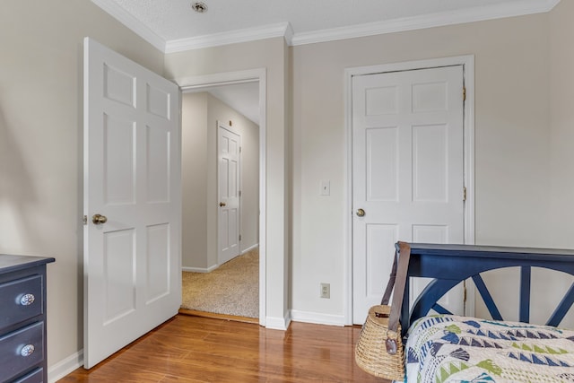 bedroom with crown molding, light wood-type flooring, and a textured ceiling