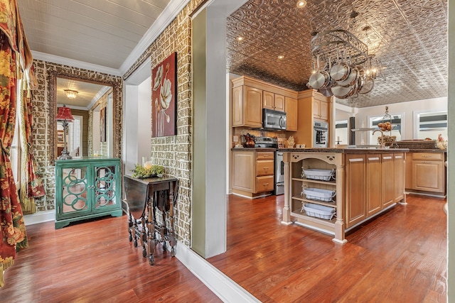 kitchen featuring stainless steel appliances, light brown cabinets, crown molding, and hardwood / wood-style floors