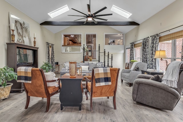 living room featuring lofted ceiling with skylight, ceiling fan, and hardwood / wood-style floors