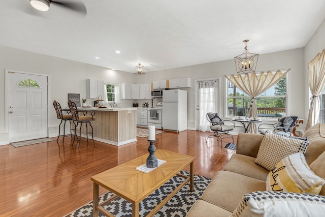 living room featuring light hardwood / wood-style flooring, an inviting chandelier, and a wealth of natural light