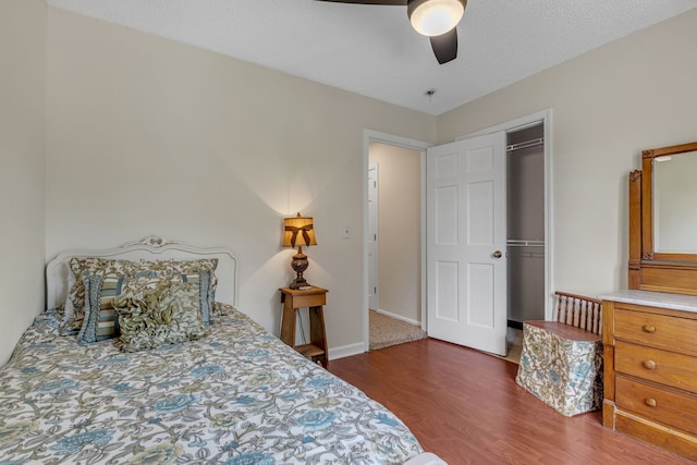 bedroom with dark hardwood / wood-style flooring, a closet, and ceiling fan