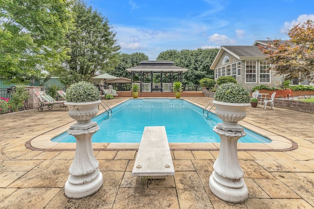 view of swimming pool with a diving board, a patio area, and a gazebo