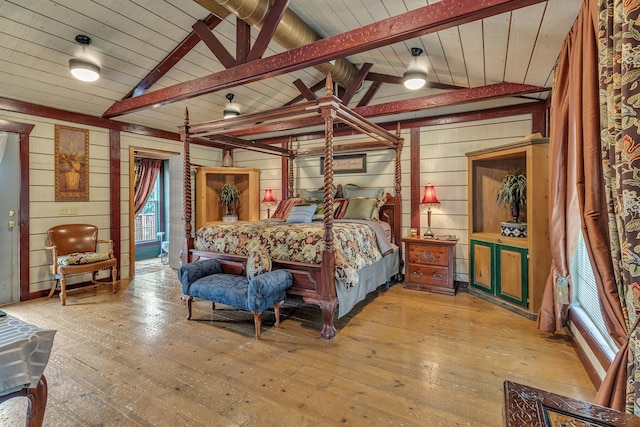 bedroom featuring hardwood / wood-style flooring, vaulted ceiling with beams, and ceiling fan