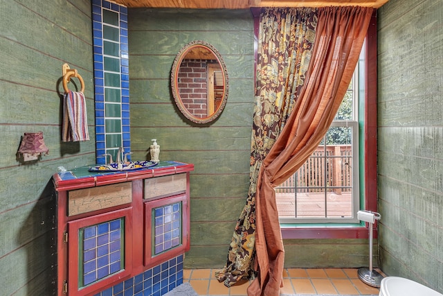 bathroom featuring vanity, toilet, tile patterned floors, and wooden walls