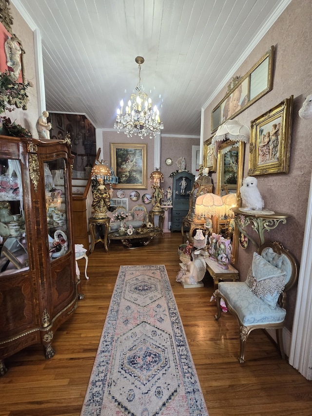 interior space featuring wood-type flooring, crown molding, and a chandelier