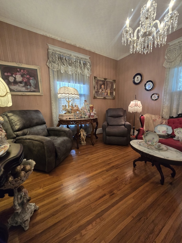 living room featuring hardwood / wood-style flooring, crown molding, and a chandelier