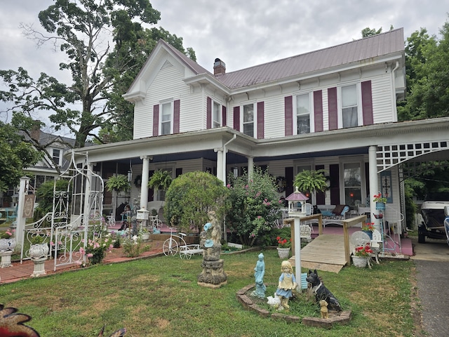 rear view of property with a porch and a lawn