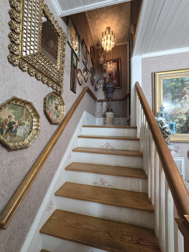 stairway featuring a notable chandelier and crown molding