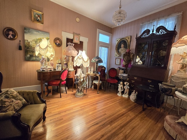 sitting room with a notable chandelier, crown molding, and hardwood / wood-style floors