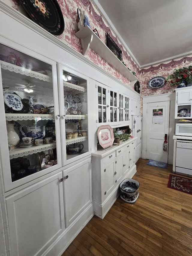 interior space with white cabinets, dark hardwood / wood-style flooring, and white appliances