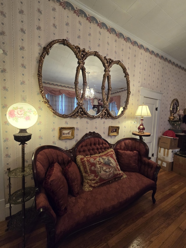 living room with a notable chandelier, ornamental molding, and hardwood / wood-style flooring