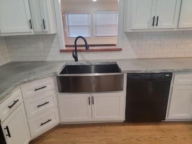 kitchen featuring dishwasher, backsplash, white cabinets, sink, and light stone counters